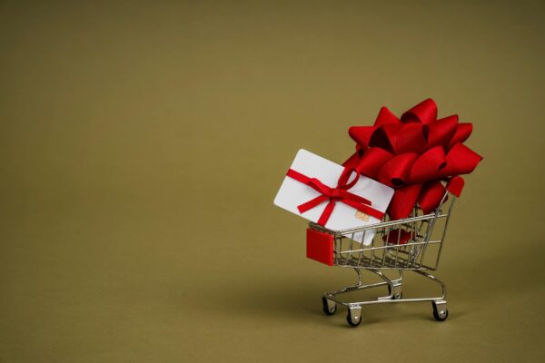 A Mini Shopping Cart with a Bank Card Wrapped in a Red Ribbon